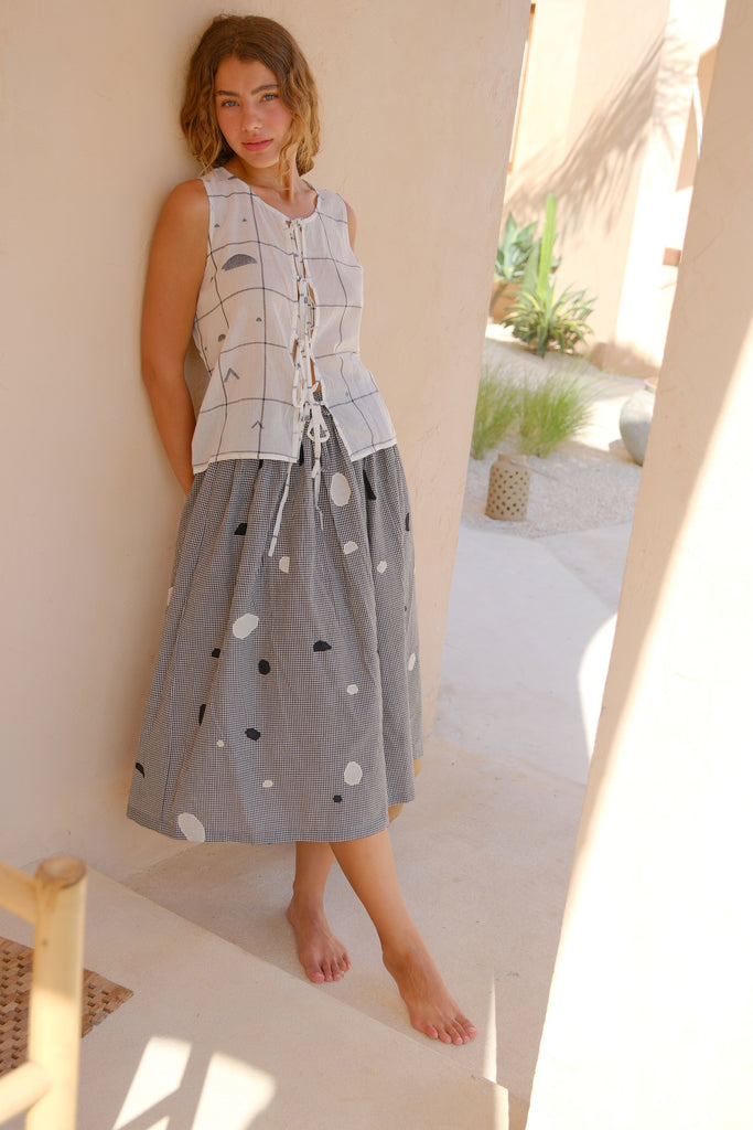 Introducing our All Dots Are Not Black Skirt, a collaboration between Audrey E Leary and World of Crow. This grey midi skirt showcases distinctive black and white polka dots on handwoven cotton, offering both comfort and style. Sustainably made, it's perfect for everyday wear.