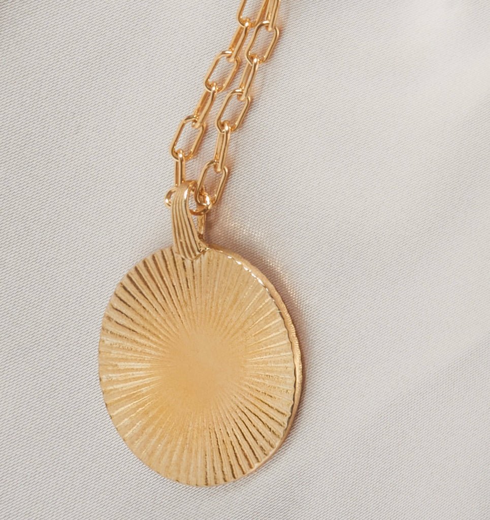 Introducing the Vintage-Inspired Gold Sunburst Pendant Necklace. This elegant gold disc features a sunburst design, gracefully suspended from a 21" chain. Choose between a 14K Gold Plated Curb Chain or a 14K Gold Filled Link Chain for a touch of customizable sophistication.