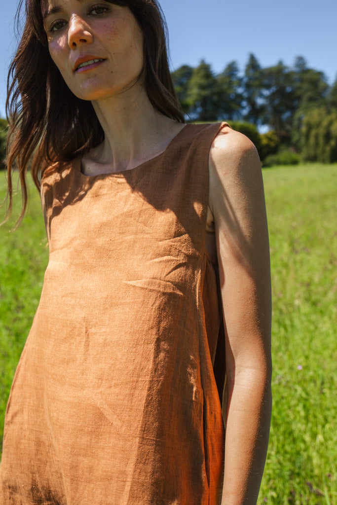 This noon dress is made in collaboration between Erica Kim and World of Crow, it has linen fabric, Brown rustic color, sleeveless, above knee-length dress, it is sustainably made and true to size