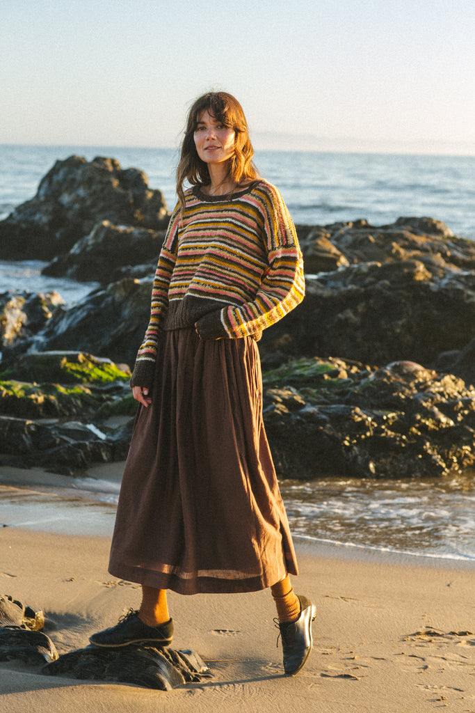 The Chocolate Brown Pull-On Skirt blends comfort and elegance. Made from handwoven cotton, it features a mid-rise elasticated waistband and a mid-calf length for a relaxed yet polished look