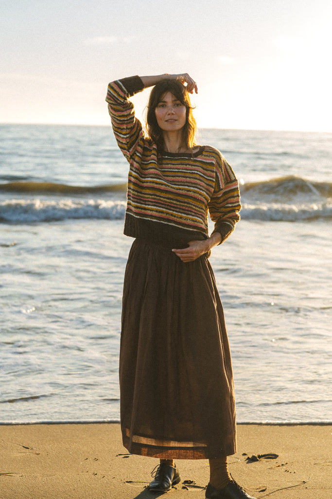 The Chocolate Brown Pull-On Skirt blends comfort and elegance. Made from handwoven cotton, it features a mid-rise elasticated waistband and a mid-calf length for a relaxed yet polished look