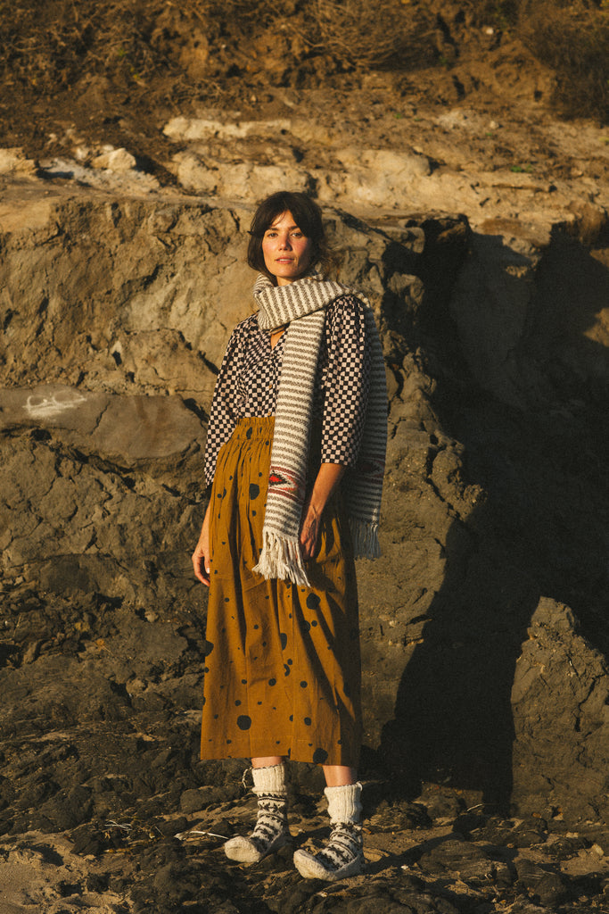 The Circles All Over Skirt features a striking brown and navy block print with circular patterns. Made from 100% handwoven cotton, it offers a comfortable mid-rise elasticated waistband and a chic mid-calf length, perfect for a polished yet relaxed style.