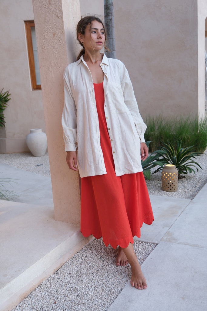 Introducing the White Artist Smock, a collaboration between Audrey E Leary and World of Crow. This short-length smock, crafted from thick, handwoven organic cotton, features a straight collar, puff full sleeves, and gathered cuffs. With spacious pockets and a comfortable fit, it's ideal for painting, crafting, and staying cozy during travel.