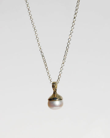 Introducing the exquisite white pearl pendant, gracefully suspended on an adjustable 16"-20" sterling silver chain. Available in both brass and sterling silver, this pendant combines timeless elegance with versatility. Elevate your style with this classic piece, designed to enhance any look with its refined simplicity.