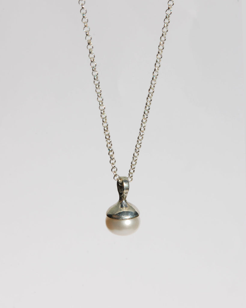 Introducing the exquisite white pearl pendant, gracefully suspended on an adjustable 16"-20" sterling silver chain. Available in both brass and sterling silver, this pendant combines timeless elegance with versatility. Elevate your style with this classic piece, designed to enhance any look with its refined simplicity.